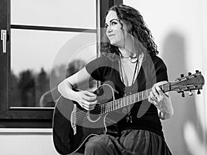 Happy woman playing acoustic guitar