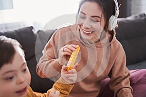 Happy woman playing at the building kit with her son with down syndrome