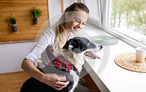 Happy woman playing with her dog at home. People pet lifestyle concept