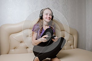 Happy woman playing video games, sitting on bed holding joystick