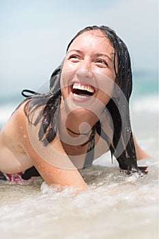 Happy woman playing in the water at the beach