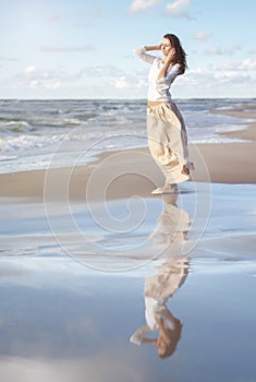 Happy woman. Portrait of the beautiful girl. Woman on the beach. Wind develops hair. photo