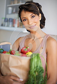 Happy woman, portrait and grocery bag with vegetables or fresh produce in kitchen at home. Female person, shopper or