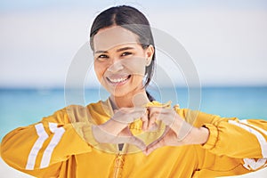 Happy woman, portrait and heart hands on beach for love, care or support in trust, health or romance. Outdoor female