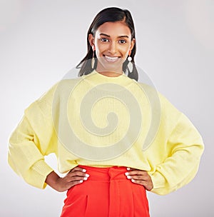 Happy woman, portrait smile and confidence standing isolated with hands on hips against a gray studio background. Face