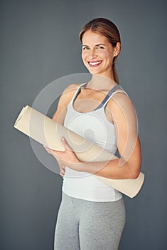 Happy woman, portrait smile and yoga mat for exercise, healthy wellness or workout against a grey studio background