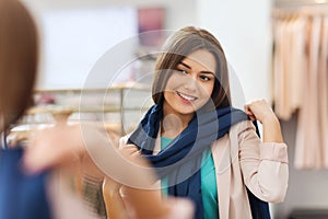 Happy woman posing at mirror in clothing store