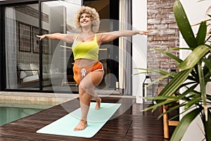 Happy Woman Practicing Yoga by Poolside at Home