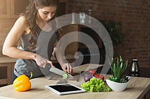 Happy woman preparing healthy food in the home kitchen