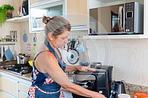 Happy woman is preparing proper meal in the kitchen