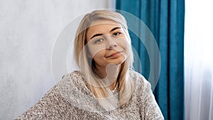 Happy woman in pullover looking at camera with smile