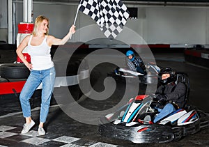 Happy woman with race flag and man driving car