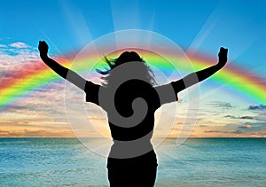 Happy woman with raised arms on a rainbow background