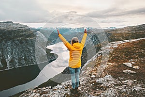 Happy woman raised hands on mountain summit