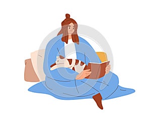 Happy woman reading book with cute cat sleeping on her. Pet owner covered with blanket, sitting with kitty at home