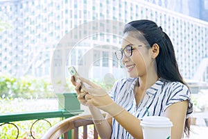 Happy woman reading message on cellphone in cafe