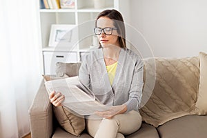 Happy woman reading newspaper at home