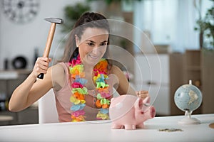 Happy woman ready to break piggy bank