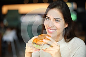 Happy woman ready to eat burguer in a restaurant photo