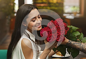 Happy Woman Receiving Bouquet From Her Loving Boyfriend In Cafe