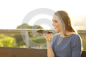 Happy woman recording audio on her phone