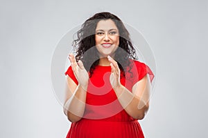 Happy woman in red dress applauding