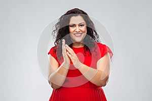 Happy woman in red dress applauding