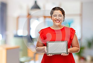 Happy woman in red dress holding tablet computer