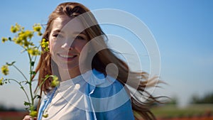 Happy woman with red hair turning around in slow motion on blue sky background.