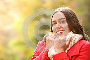 Happy woman in red keeping warmth in autumn