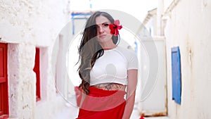 Happy woman in red long skirt and with a red flower in her hair