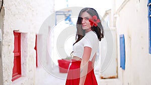 Happy woman in red long skirt and with a red flower in her hair