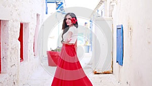 Happy woman in red long skirt and with a red flower in her hair