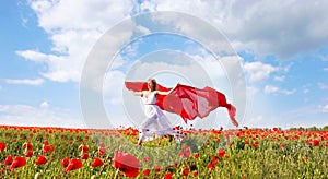 Happy woman with red scarf in poppy field