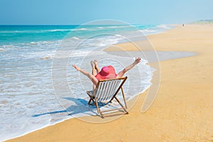 Happy woman in red sunhat on the beach