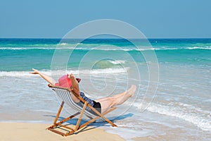 Happy woman in red sunhat on the beach