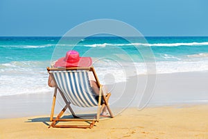 Happy woman in red sunhat on the beach