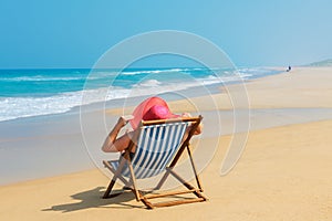 Happy woman in red sunhat on the beach