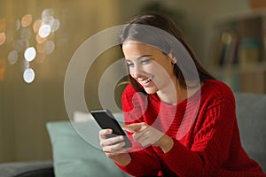 Happy woman in red using mobile phone in the night