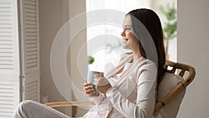 Happy woman relax in chair enjoy coffee or tea