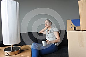 Happy woman relax on a sofa during a move into a new home