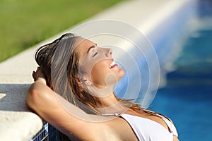 Happy woman relaxed in a swimming pool enjoying vacations