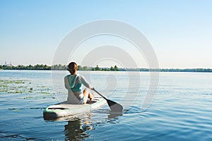 Happy woman relaxes on SUP board and enjoy life