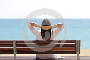 Happy woman relaxing contemplating ocean on the beach