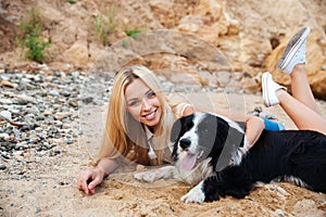 Happy woman relaxing with dog on the beach