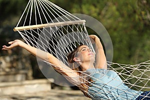 Šťastný žena relaxační na hamak na dovolená zvyšování paže 