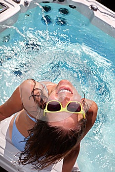 Happy woman relaxing in hot tub.