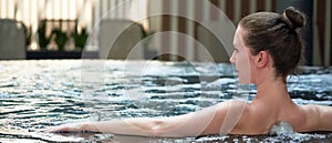Happy woman relaxing in indoor swimming pool, enjoying jacuzzi