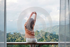 Happy woman relaxing and looking mountain view at countryside home or homestay in the morning. Vacation, blogger, SoloTravel,