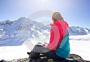 Happy woman relaxing on the top of mountain under blue sky with sunlight at sunny winter day, travel vacation, landscape mountains